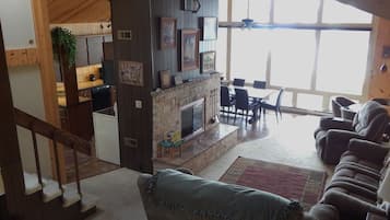 A spacious living area with a fireplace, a dining table, and a sofa.