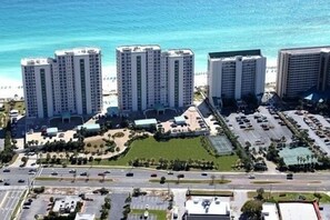 Un grand hôtel à plusieurs étages, doté d’un parking et offrant une vue sur la plage.
