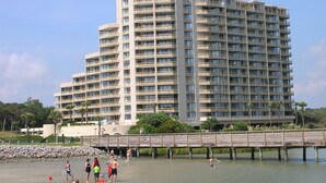 Ein mehrstöckiges Hotel mit Balkonen in der Nähe eines Hafens mit einer hölzernen Pier.