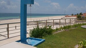 A beach view with a blue tiled structure, a pool, and a fence.