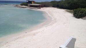 Une plage avec une tour de surveillance pour les sauveteurs et un bâtiment en bois.