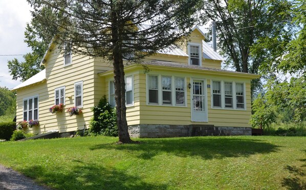 A yellow house with a stone foundation, large windows, and a chimney. - Unique FarmStay Experience in The Catskills! (Durham)