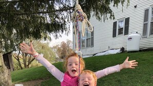 Two children on a swing in a grassy yard with a house in the background. - Unique FarmStay Experience in The Catskills! (Durham)