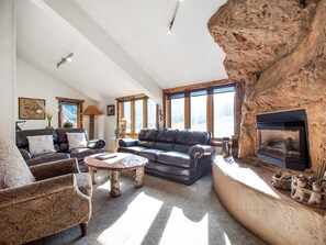 Living room with artistic fireplace and vaulted ceilings