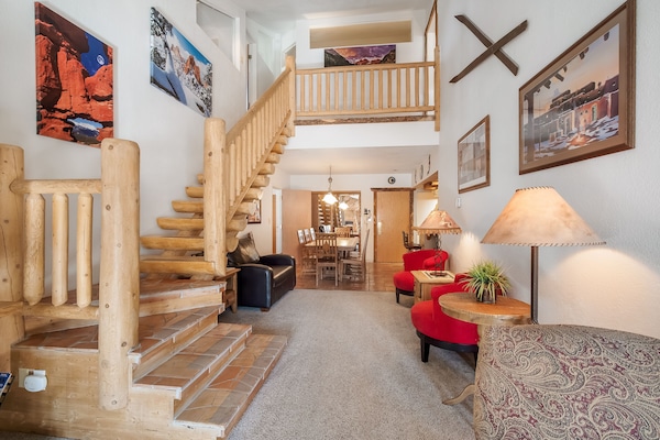 View from living room of stair case to second floor and dining room