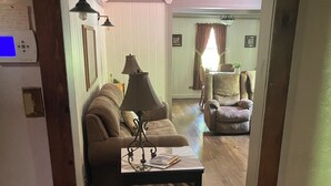 A cozy living room with a wooden herringbone coffee table, two sofas, and a dining area with a table and chairs.
