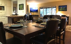 Enjoy meals in the spacious dining area with a large table, comfortable chairs, and a view of the outdoors.