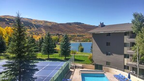 A hotel with a swimming pool, tennis court, and views of a lake and mountains. - Spacious Condo w/ FREE WiFi, Parking, Heated Pool, Hot Tubs, Skier Shuttles (Avon)
