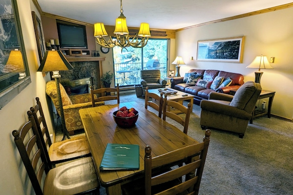 Living room with sofa bed, gas fireplace, dining table, and balcony w/ gas BBQ