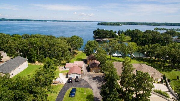 A residential area with houses, a golf course, and a large body of water.