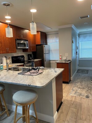Enjoy cooking in this well-lit kitchen with a central island and stainless steel appliances.