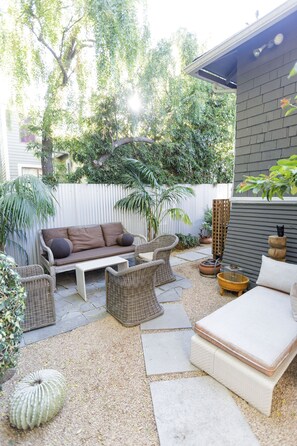 A patio with wicker furniture, a white sofa, and a small table.