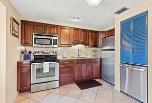 Enjoy cooking in this well-equipped kitchen with a microwave, oven, and refrigerator.