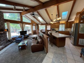 Relax in a spacious living area with a comfortable sofa, flat-screen TV, and dining table.