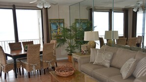 Hotellihuone, jossa on ruokailutila, sohva, sohvapöytä ja ruukkukasvi.