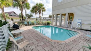 A swimming pool with a tiled deck, surrounded by palm trees and a fence. - Last Minute Rates, Beach Front Home, 3Beds, 3.5 Bath, Full Ocean View (Panama City Beach)