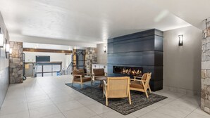 A spacious living area with a fireplace, stone walls, and a staircase leading to an upper level. - Best location in Breckenridge - Downtown - Ski In Ski Out - 1 Bedroom Condo (Breckenridge)