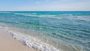 A beach with clear turquoise water and a sandy shore.