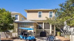 A residential property with a covered patio, a golf cart, and bicycles.
