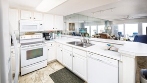 A modern kitchen with white cabinets, a built-in oven, a microwave, and a dishwasher. - Islander Beach 2003 • 3BR 3BA, Amazing Direct Ocean View, Large Pool, Free Beach Service (Fort Walton Beach)