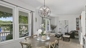 A dining area with a round wooden table, chairs, and a chandelier.