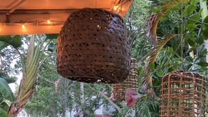 A hanging basket with a woven design, surrounded by lush green foliage and a stone pathway. - DELRAY BEACH  Private Pool, Close To Sea (Delray Beach)