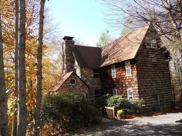 A log cabin with a stone chimney, wooden siding, and a small porch with potted plants. - FIELDSTONE AND LOG HOME ON BEECH.   
Ski season dates available at 2024 prices! (Beech Mountain)