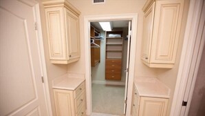 A narrow hallway with cream-colored cabinetry and a central closet with hanging space. - Beachfront Condo with Pool (Holmes Beach)