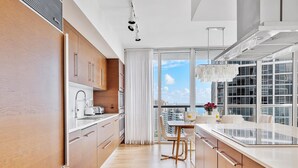 Una cocina moderna con armarios de madera, un comedor con vistas a la ciudad y un ventanal grande.