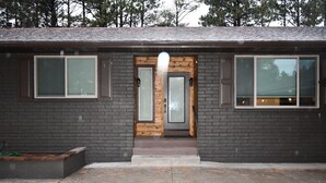 A modern building with a brick facade, large windows, and a wooden door. - Luxury Ranch House on Continental Golf Course, Great for families, Remodeled.  (Flagstaff)