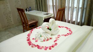 A hotel room with a bed, a table, and two chairs. - Noahgarden (Cotonou)