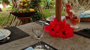 A table set with a glass, a pitcher with a drink, and a bowl of fruit. - House of Palms (Teouma)