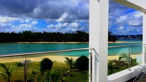 A balcony with a view of a beach and turquoise waters. - Paradise Point Views (Port Vila)