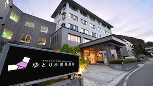 A modern hotel with a signboard displaying the name and logo.