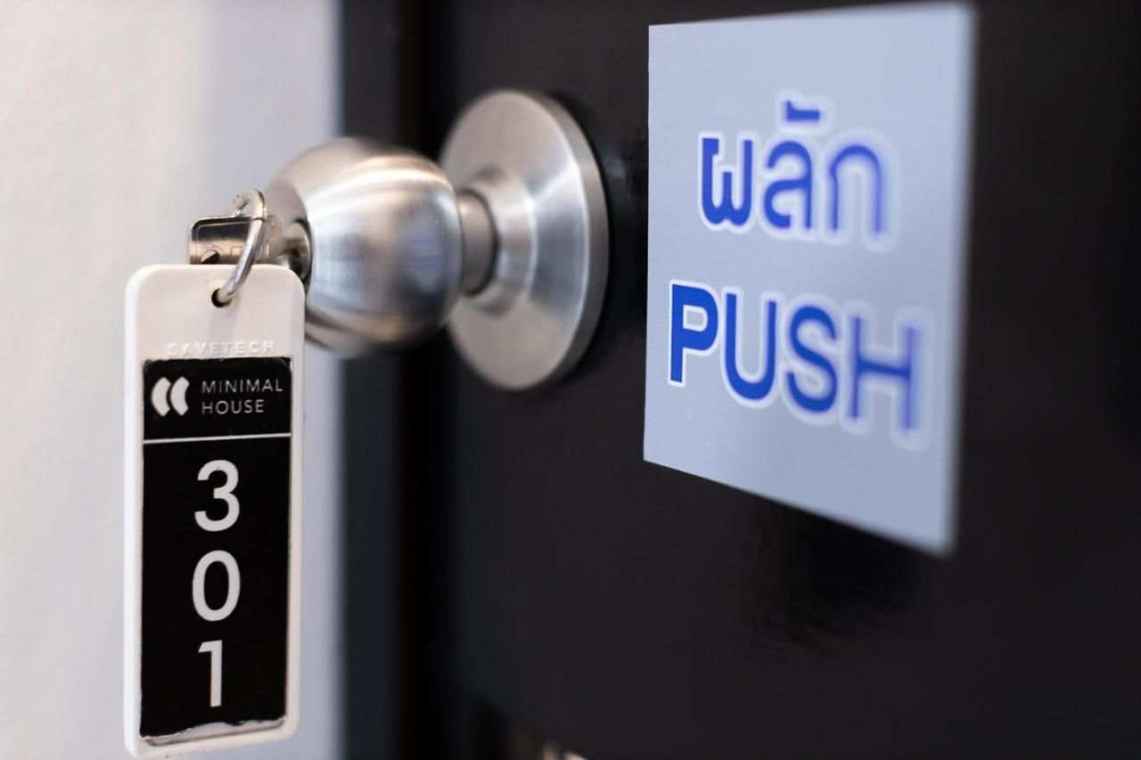 A door with a keycard labeled 'SAVETECH MINIMAL HOUSE 301' and a sign that says 'wān PUSH'.