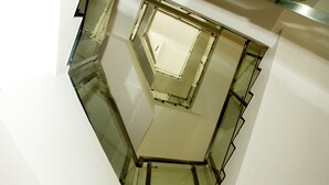 Eine Wendeltreppe mit Glasgeländern und heller Innenarchitektur.