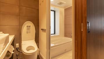 Une salle de bain moderne équipée de toilettes, d’une douche et d’une baignoire.