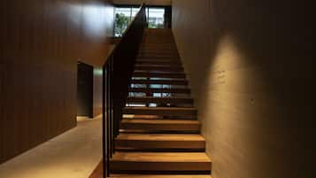A modern staircase with wooden steps and a metal railing, leading to a room labeled "TOKYO GRAFT ROOM".