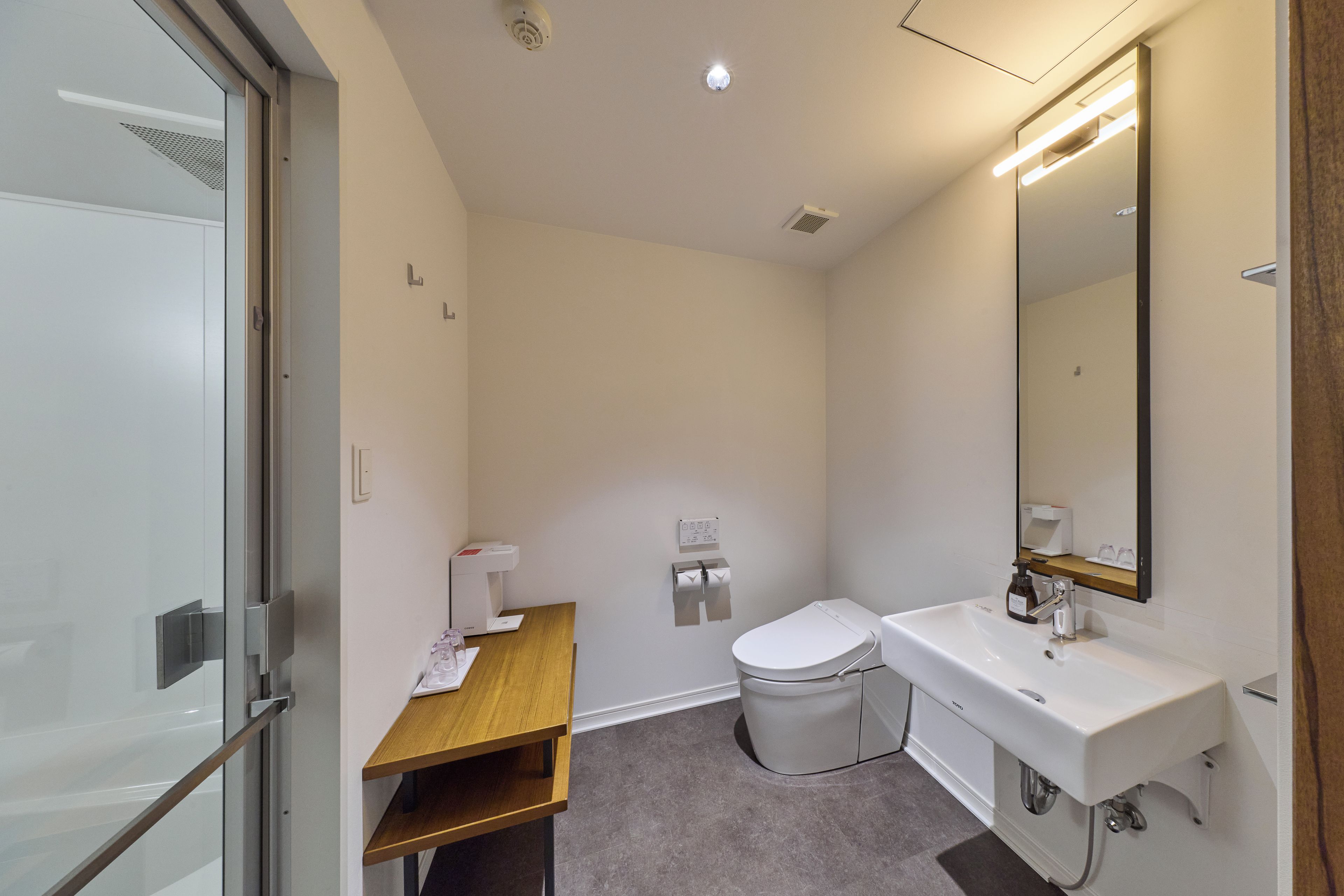 Ein modernes Badezimmer mit Toilette, Waschbecken und Spiegel.