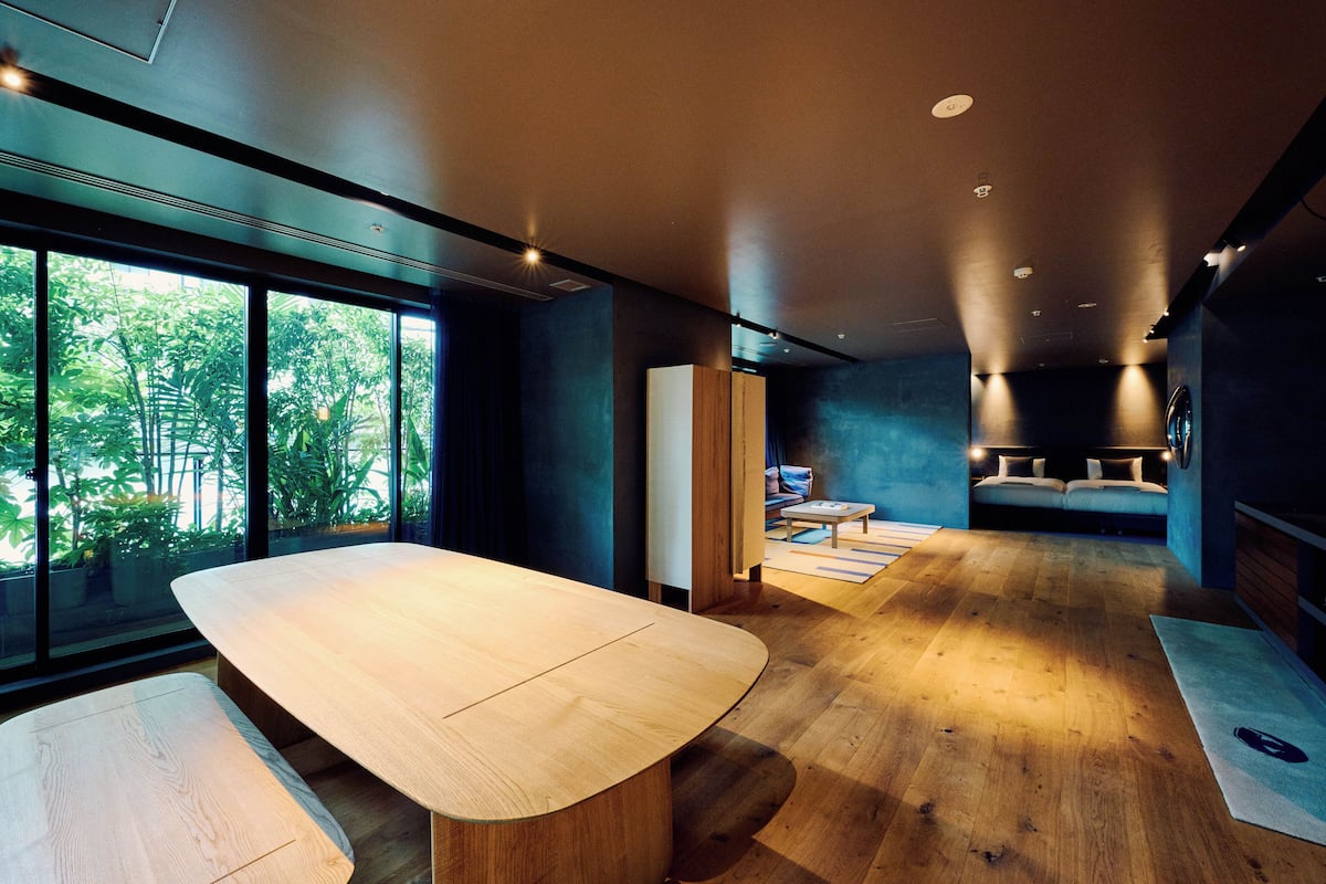 Un interior moderno con una mesa de madera, un sofá y una cama.