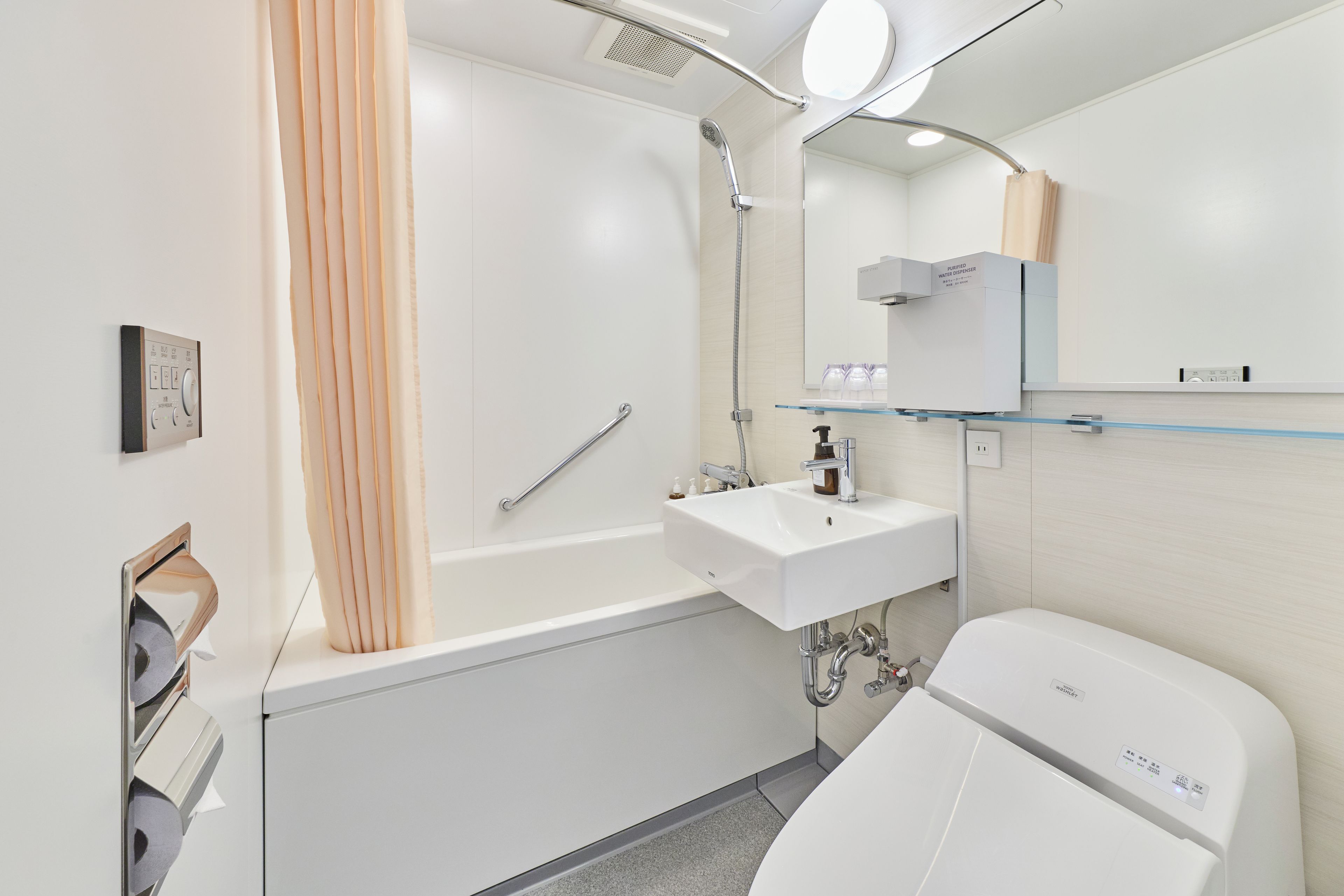 Ein modernes Badezimmer mit Badewanne, Waschbecken, Toilette und einer Glasablage.