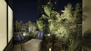 Una terraza al aire libre con asientos, plantas y faroles.