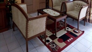 Una sala de estar con dos sillones, una mesa de centro, un televisor y un sistema de sonido.