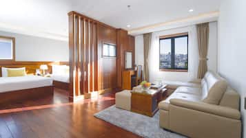 Habitación de hotel con cama, sofá, escritorio y vistas a la ciudad.