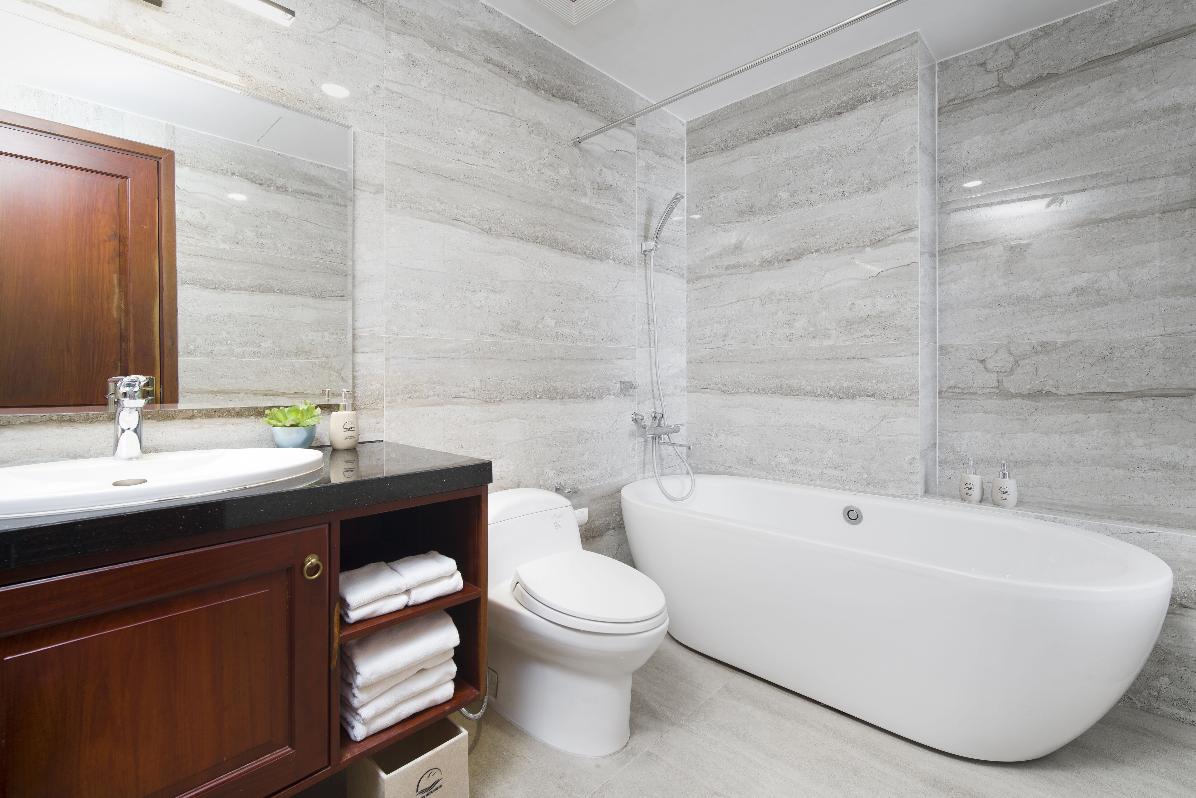 Une salle de bain moderne avec une baignoire sur pieds, des toilettes et un meuble-lavabo avec un évier et un miroir.