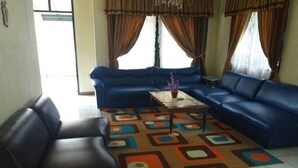 Un salón con un sofá azul, una mesa de centro y una alfombra estampada.