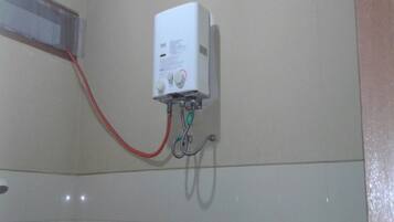 A white electrical box mounted on a wall with a red wire connected to it.