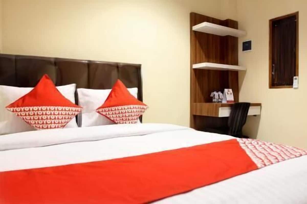 Ein Hotelzimmer mit Bett, Kissen, Schreibtisch und Stuhl.