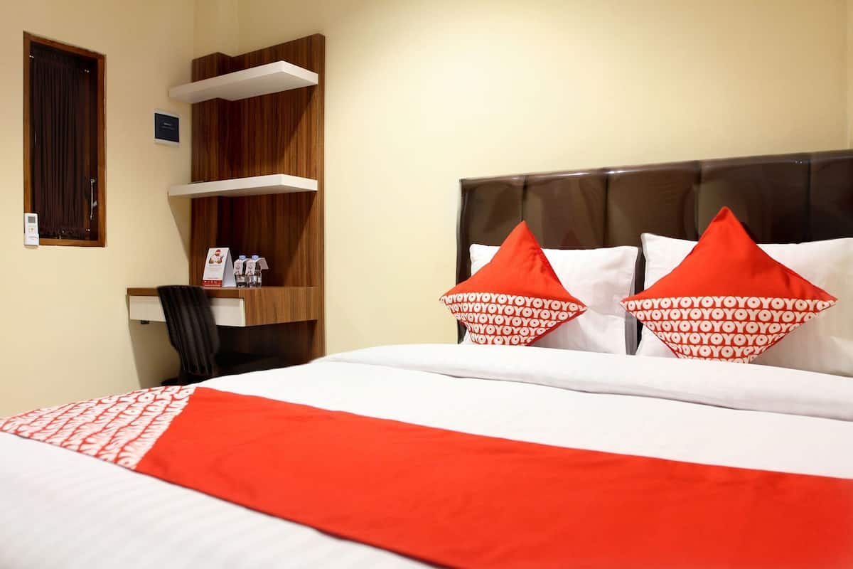 Ein Hotelzimmer mit Bett, Schreibtisch und Regaleinheit.