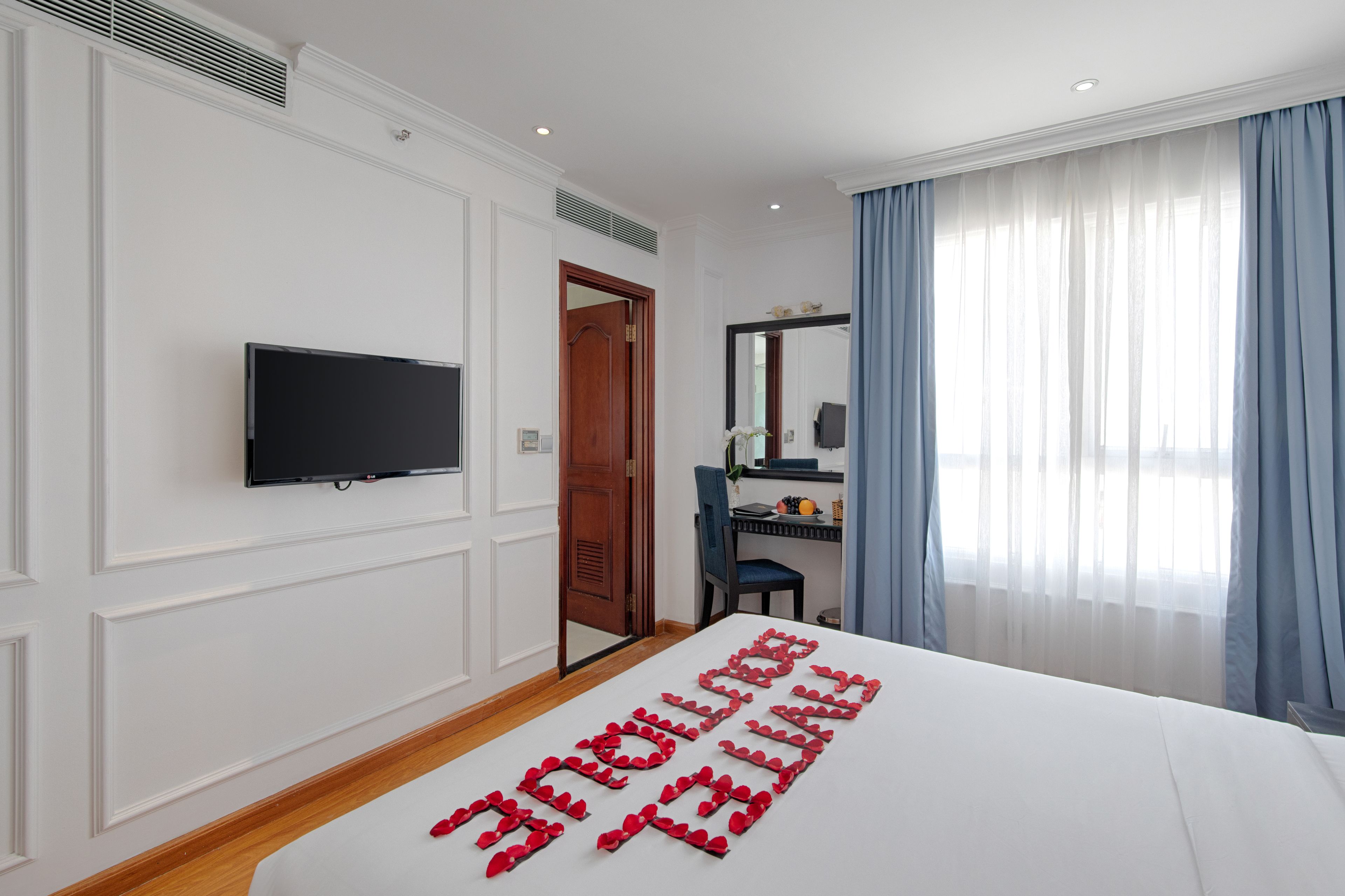 A hotel room with a bed, a television, a desk, and a chair.